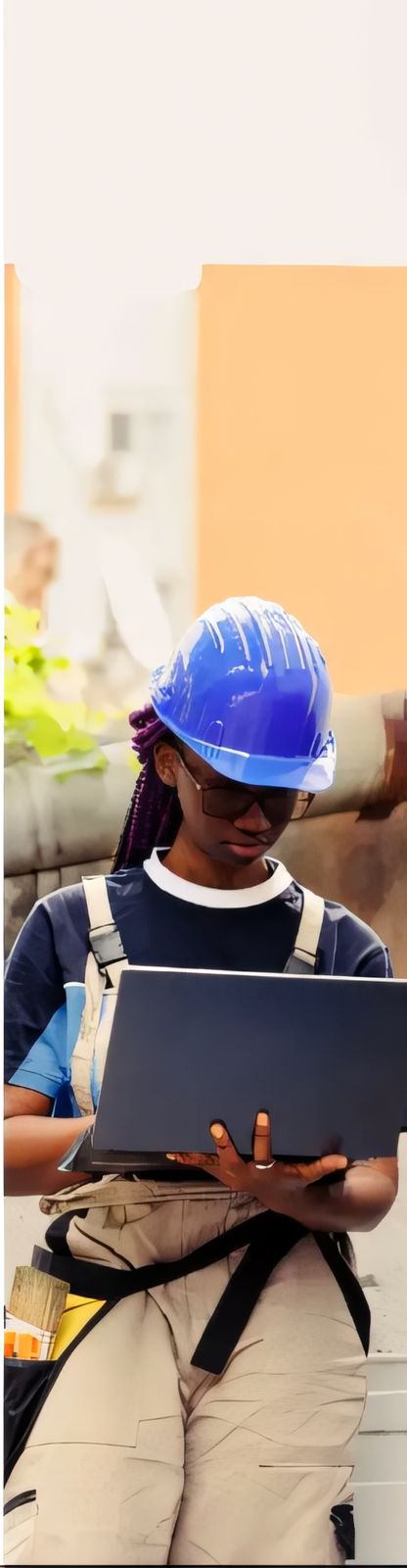 ELSIM site engineer in a blue hard hat reviewing project data on a laptop on site